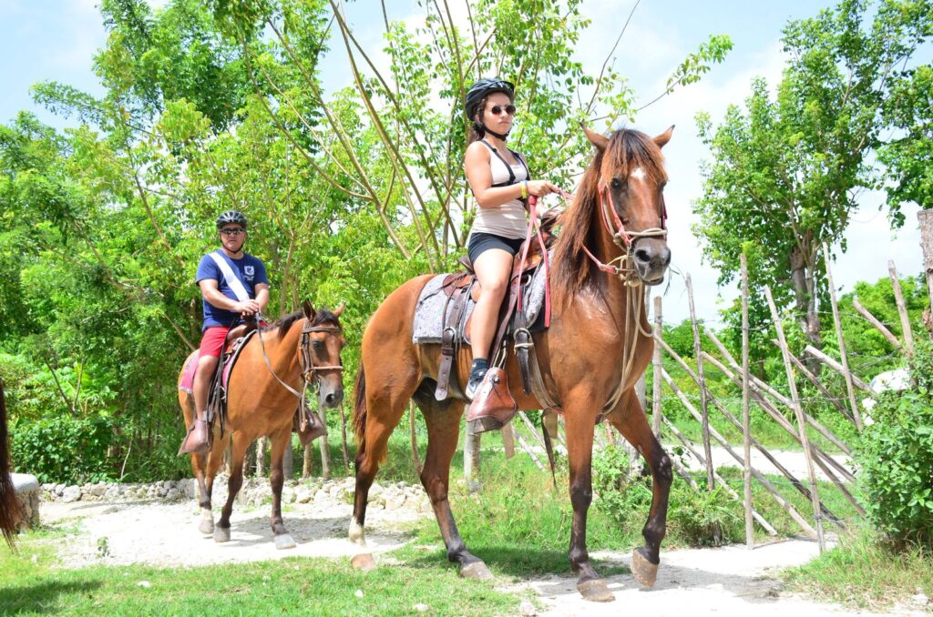 Horseback riding tour in Punta Cana with riders exploring tropical trails and beach landscapes in the Dominican Republic.